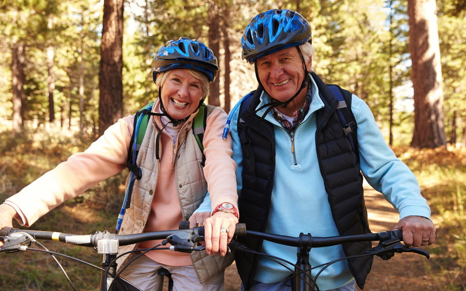 altes Paar auf Mountainbikes in einem Wald